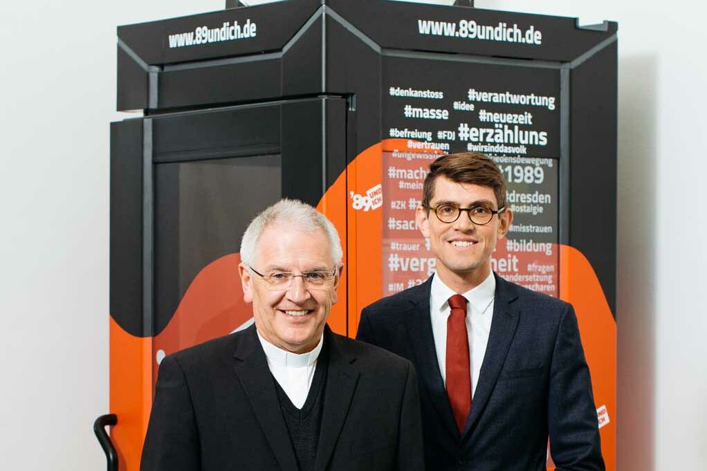 Bischof Heinrich Timmerevers und Dr. Thomas Arnold (Direktor der Katholischen Akademie des Bistums Dresden-Meißen) vor der Telefonzelle. (Foto: Oliver Killig)