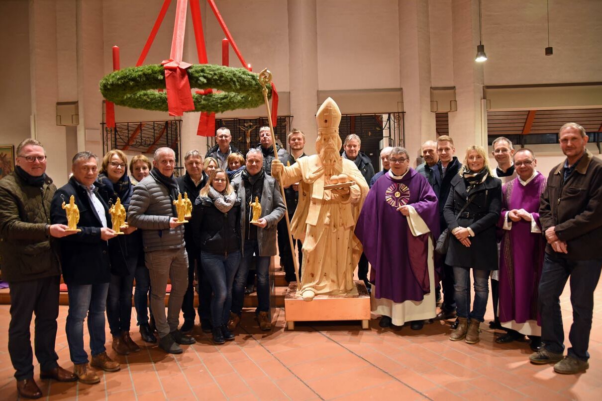 Sponsoren und Kirchengemeinde freuen sich über die neue Nikolausholzfigur, die jedes Jahr am Eingangsportal zum Nikolausmarkt in Hövelhof stehen wird. (Foto: Patrick Kleibold)