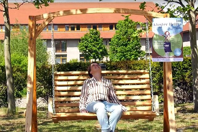 Bettina Albrecht mit dem Plakat des Frauenfestes 2021 (Foto: aus dem Video "Zwischen Himmel und Erde – Frauenbegegnung im Kloster Helfta“), von Bettina Albrecht)