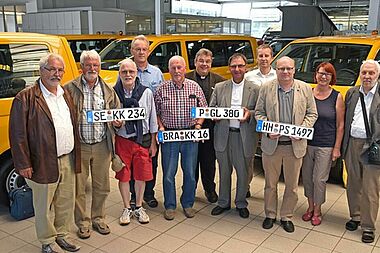 Monsignore Georg Austen (Mitte) übergab in Paderborn an die Vertreter von vier Kirchengemeinden und Institutionen aus den Erzbistümern Hamburg und Berlin und dem Bistum Münster einen rapsgelben BONI-Bus. Foto: Lena Reiher