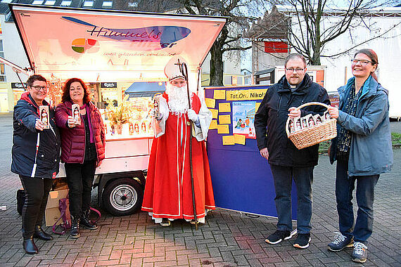 Die Ehrenamtlichen Andrea Flecks und Claudia Lechleitner, Bischof Nikolaus, Diakon Christian Mersch und Gemeindereferentin Andrea Kreklau (v.l.) verteilen Schokonikoläuse an Passanten in Dortmund. (Foto: Theresa Meier)