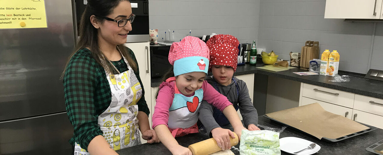 Die Kinder haben sichtlich Spaß beim Teig ausrollen für die "Käsefüße". (Foto: Anna Hartmann)