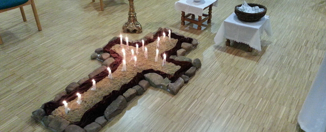 Als sichtbares Zeichen wurde bei der Wortgottesfeier der Gemeinde St. Peter und Paul in Westheim eine brennende Kerze in ein mit Sand gefülltes Kreuz gesteckt. (Foto: Werner Vierheilig)