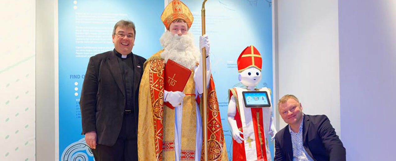 Verkleidet als Nikolaus wird Roboter Pepper den Besuchern des HNF eine kleine Freude machen. Von Links: Monsignore Georg Austen, Bischof Nikolaus, Roboter Pepper und Jochen Viehoff. Foto: Jan Braun/HNF