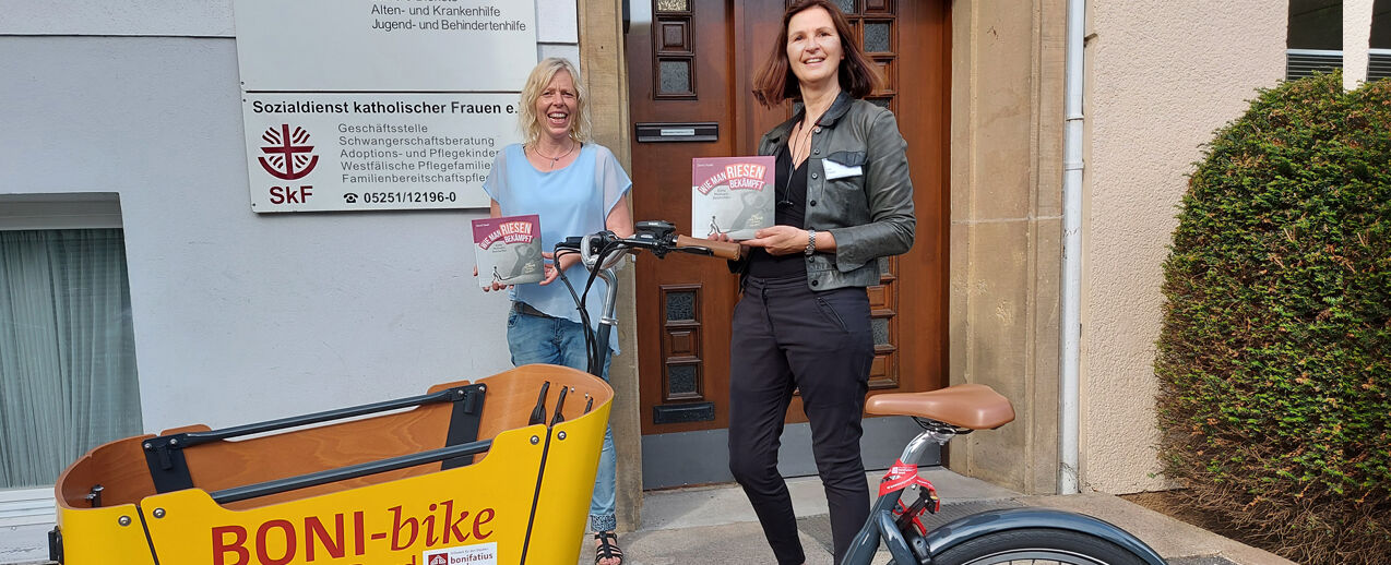 Anke Füser vom Bonifatiuswerk (r.) übergibt Anja Willeke von der Beratungsstelle die Mutmach-Bücher (Foto: Katrin Sijbom)