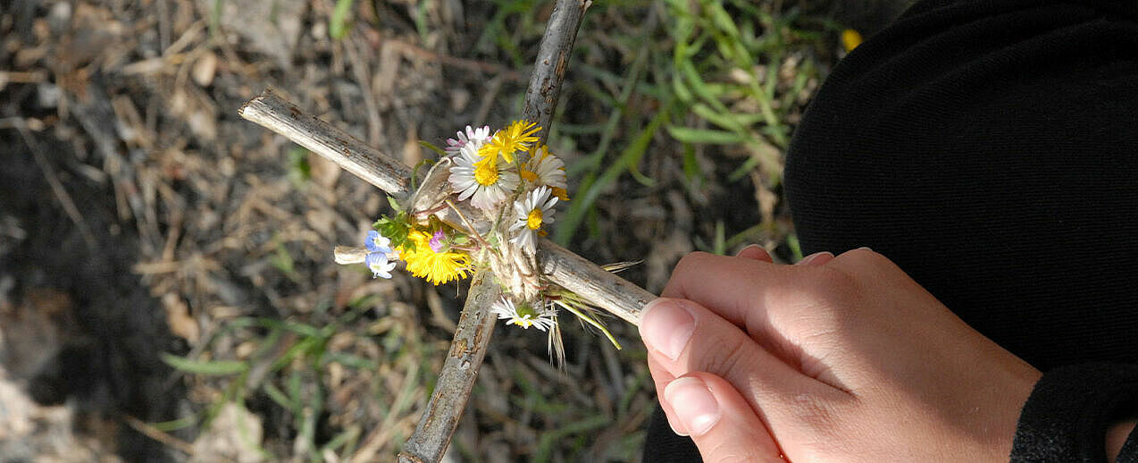 Ein mit Blumen geschmücktes Holzkreuz. (Foto: St. Benno Gymnasium))