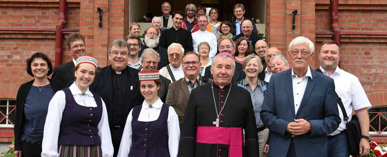 Gruppenfoto mit Bischof Pavlovskis und Studentinnen in lettischer Tracht. Foto. Sr. Theresita M. Müller