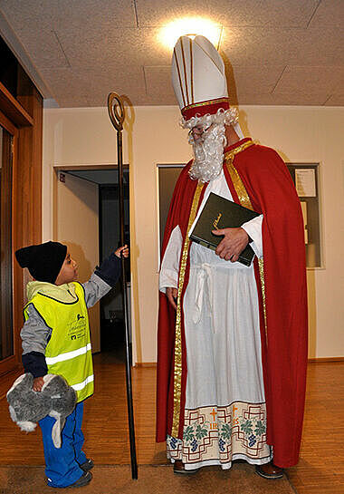 Ein kleiner Junge hält den großen Bischofsstab des Nikolaus. (Foto: Sr. Kathrin Vogt)