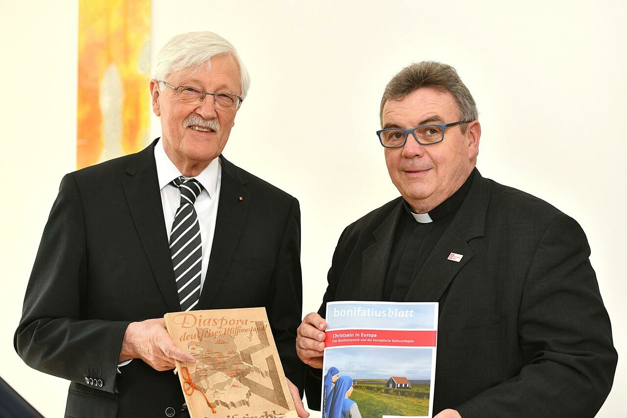 Heinz Paus (Präsident des Bonifatiuswerkes) und Monsignore Georg Austen (Generalsekretär des Bonifatiuswerkes) zeigen eine Ausgabe des Bonifatiusblatts aus dem Jahr 1949 und von 2019. (Foto: Wilfried Hiegemann)