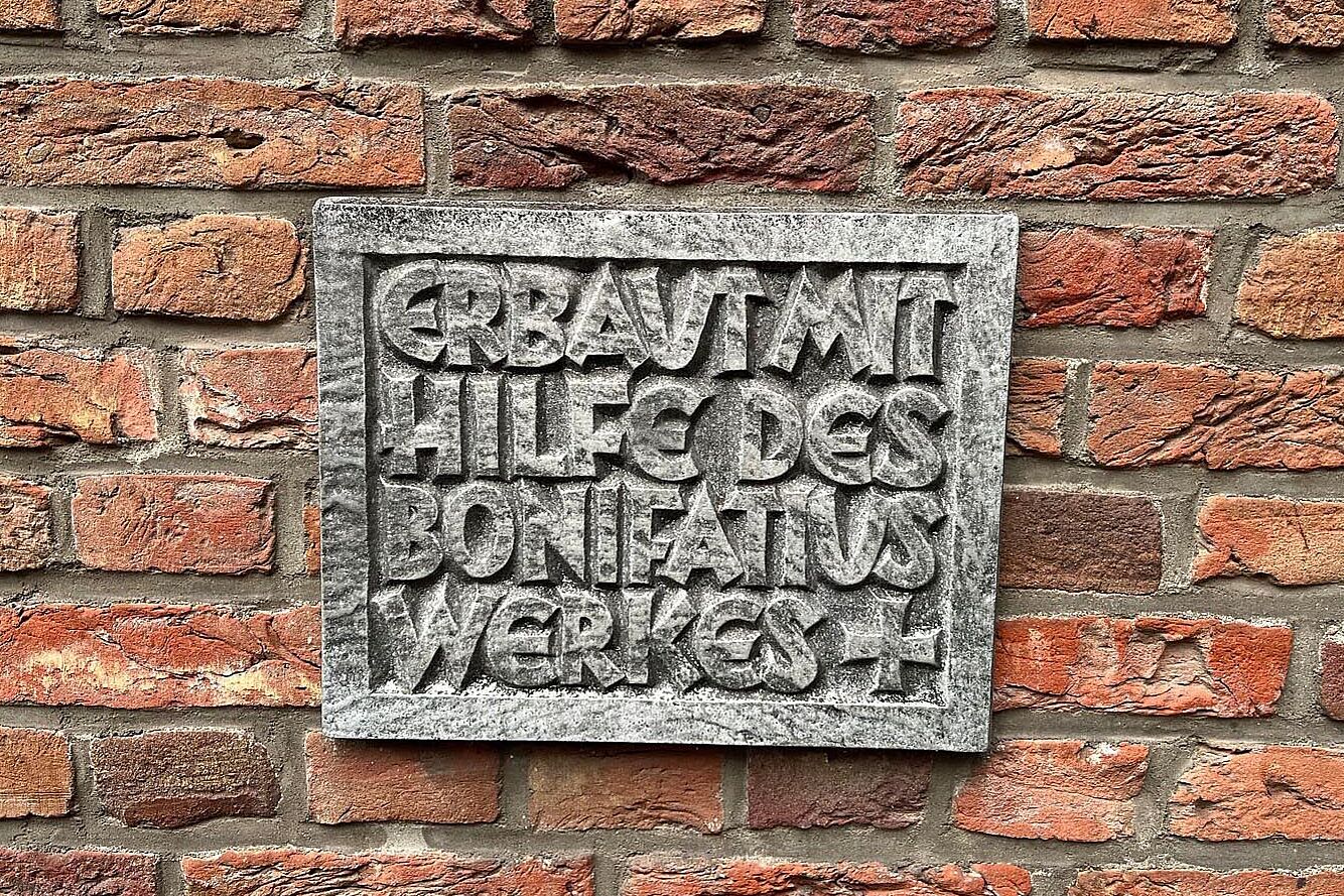 „Erbaut mit Hilfe des Bonifatiuswerkes“: Alte Plakette an der Außenfassade der St.-Joseph-Kirche in Hamburg. Foto: Marcus Thielking