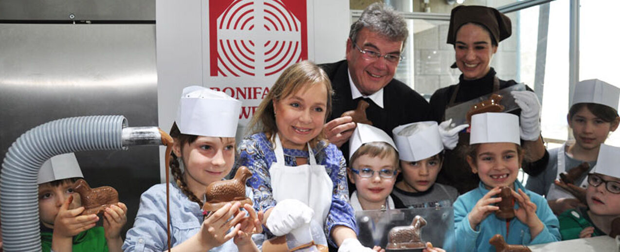 ChrisTine Urspruch (2. v. li.) goss im Schokoladenmuseum Köln mit Kindern der Kölner Kita St. Josefshaus Schokolämmer für die Osterinitiative des Bonifatiuswerkes. Mit dabei: Msgr. Georg Austen und Museumspädagogin Aiga Müller.