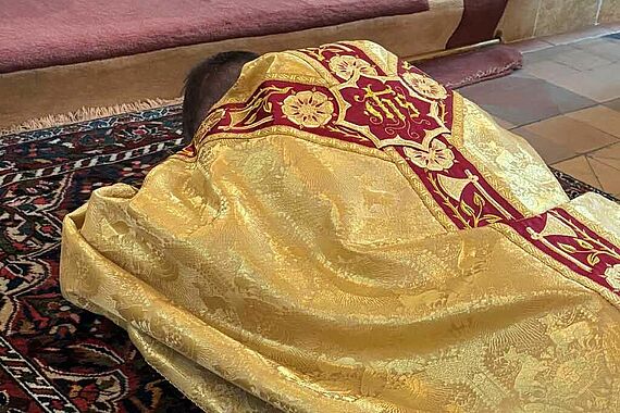 Fredrik Hansen liegt bäuchlings ausgestreckt vor dem Altar, die "Prostratio", die sogenannte Niederwerfung des künftigen Bischofs. Die Körperhaltung zeigt, dass sich der Weihekandidat ganz in Gottes Hände begibt. (Foto: G. Austen)
