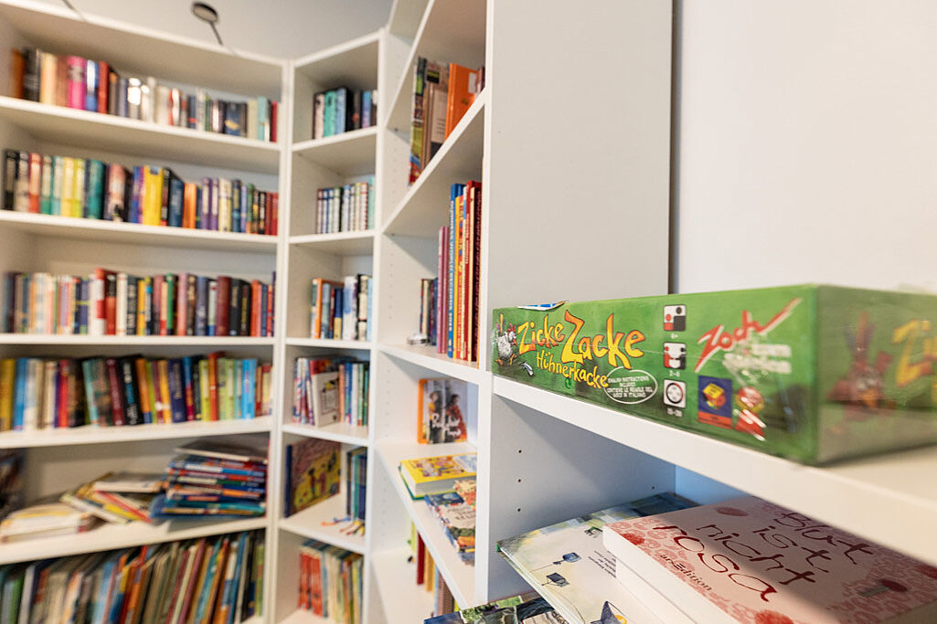 Das Bild zeigt ein Regal voller Bücher und Spiele im Haus Martha. (Foto: Hartmut Salzmann)