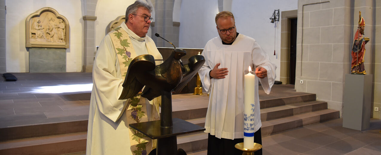 Bonifatiuswerk-Generalsekretär Msgr. Georg Austen und Julian Heese, Leiter des Bereiches "Missionarische und diakonische Pastoral" im Hilfswerk beim Entzünden der Friedenskerze. (Foto: Theresa Meier)