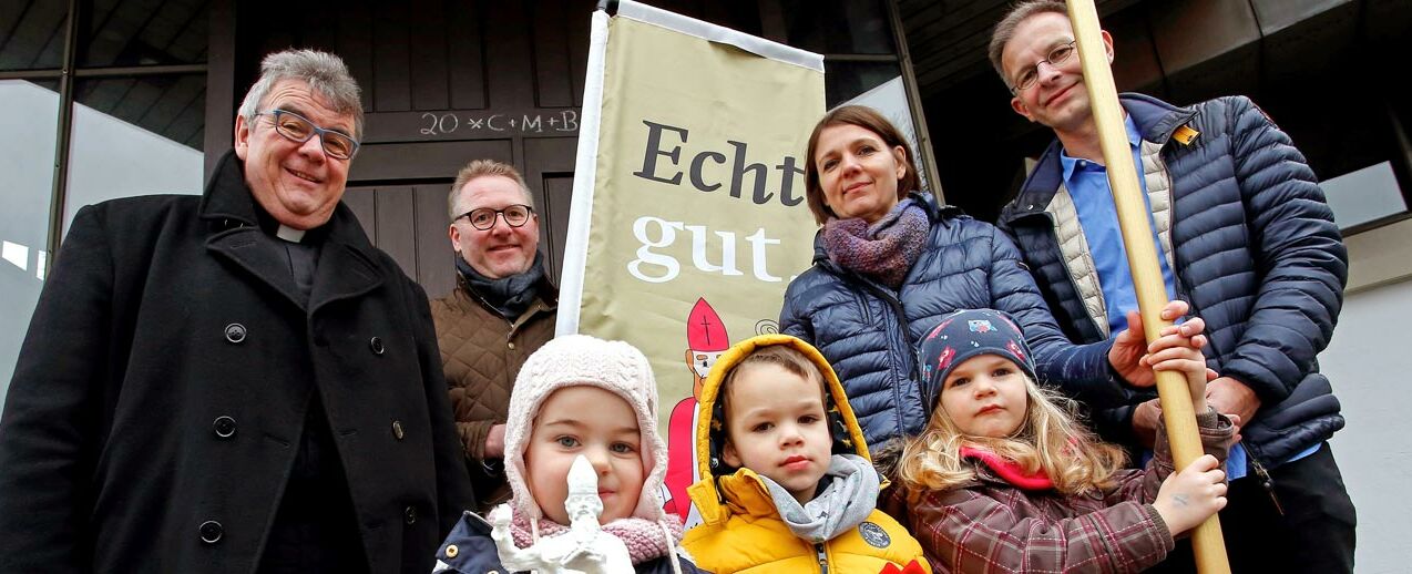 Mia (links vorne) zeigt das Modell der Nikolaus-Holzstatue, Aiden hat eine Mitra dabei und Lea hält den Bischofsstab. 