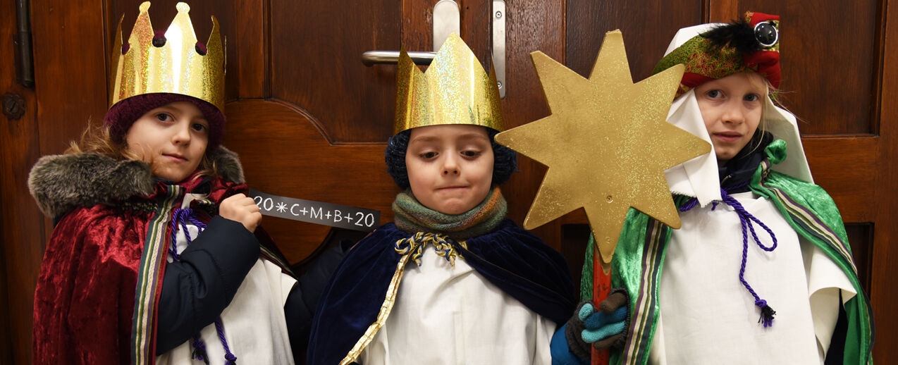 Luise, Caspar und Sarah (v.l.) segnen als Sternsinger das Bonifatiushaus in Paderborn (Foto: Theresa Meier)