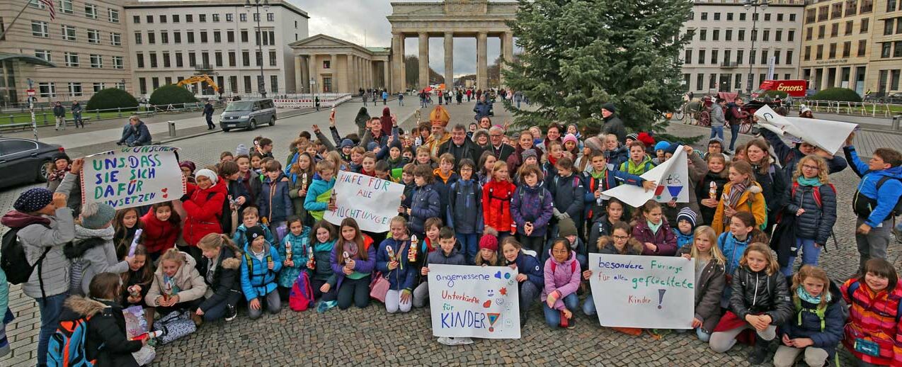 Gruppenfoto am Brandenburger Tor: Berliner Schulkinder mit Bischof Heiner Koch, Monsignore Georg Austen, Bischof Nikolaus, Maite Kelly und Eckhard Pols. Foto: Markus Nowack