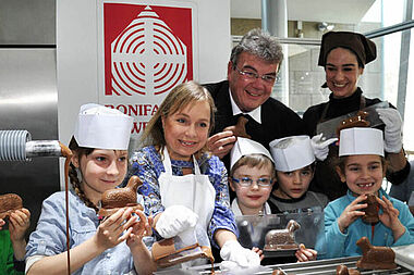 ChrisTine Urspruch (2. v. li.) goss im Schokoladenmuseum Köln mit Kindern der Kölner Kita St. Josefshaus Schokolämmer für die Osterinitiative des Bonifatiuswerkes. Mit dabei: Msgr. Georg Austen und Museumspädagogin Aiga Müller.