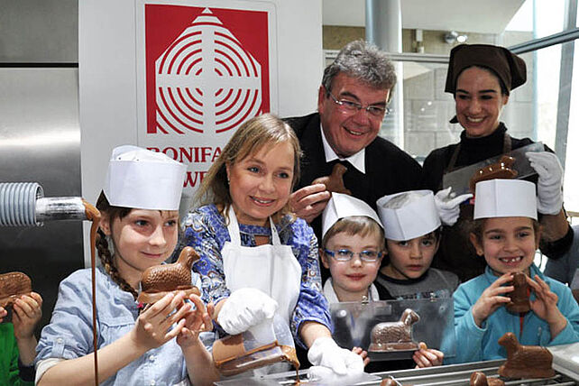 ChrisTine Urspruch (2. v. li.) goss im Schokoladenmuseum Köln mit Kindern der Kölner Kita St. Josefshaus Schokolämmer für die Osterinitiative des Bonifatiuswerkes. Mit dabei: Msgr. Georg Austen und Museumspädagogin Aiga Müller.