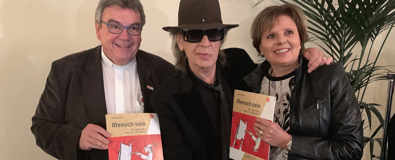 Zwei Paderborner zu Gast bei Udo Lindenberg. Der Generalsekretär des Bonifatiuswerkes, Monsignore Georg Austen (l.) und die Verlagsleiterin des Schulbuchverlags Schöningh der Westermann Gruppe, Christiane Voßhans-Schöningh (r.) präsentieren Udo Lindenberg (Mitte) die neue Arbeitshilfe Foto: privat