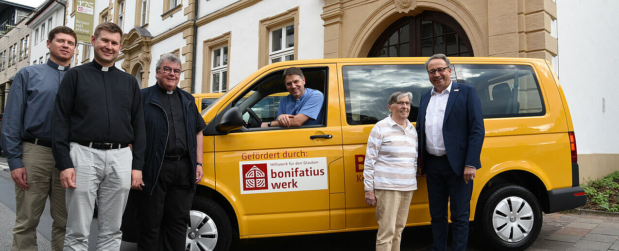 Freuen sich über die neuen BONI-Busse: Pfarrer Edgaras Versockis, Pfarrer Tomasz Materna und Pfarrer Wodzislaw Szczepanik (v.l.). Bonifatiuswerk-Generalsekretär Monsignore Georg Austen (3.vl.) dankt der Spenderin Erika Godziewski für ihre Unterstützung. Andreas Kaiser, Referent im Bonifatiuswerk-Stiftungszentrum (r.) ist ihr direkter Ansprechpartner. (Foto: Theresa Meier)