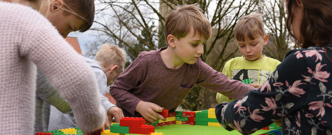 Erstkommunionkinder aus der Gemeinde St. Margaretha in Paderborn-Dahl bauen passend zum diesjährigen Bonifatiuswerk-Motto "Jesus, wo wohnst du?" ein Haus aus Duplo-Steinen. Foto: Theresa Meier