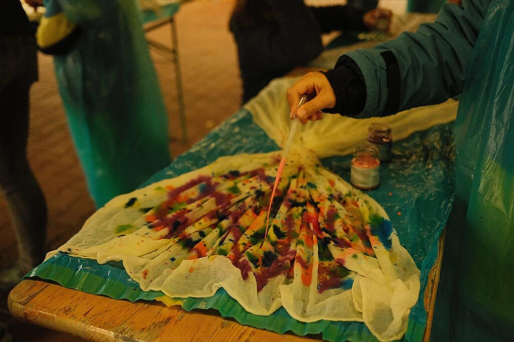 Eltern und Kinder bemalten Baumwolltücher bunt, die später als Schmetterlingsflügel genutzt werden konnten. (Foto: Anna Holtschke)