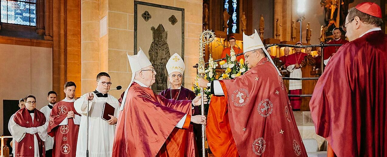 Erzbischof em. Hans-Josef Becker (links) überreicht seinem Nachfolger Erzbischof Dr. Udo Markus Bentz symbolisch den Hirtenstab. (Foto: Besim Mazhiqi/Erzbistum Paderborn)
