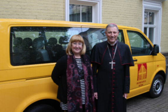 Caritas-Vorsitzende Inese Švekle mit Erzbischof Zbigņevs Stankevičs vor dem BONI-Bus. (Foto: Bistum Riga)