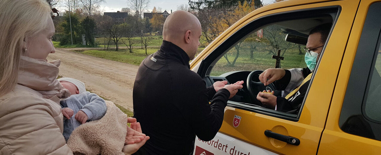 Pfarrer Gatis Mārtiņš Bezdelīga spendet einer jungen Familie die Kommunion aus dem BONI-Bus heraus. (Foto: Gemeinde Sv. Pētera un Pāvila)