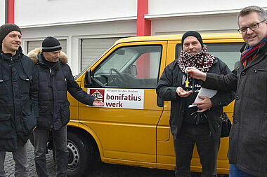 Thomas Twents (rechts) übergibt den Schlüssel des BONI-Busses an Pfarrer Pāvils Kamola (2. v. r.). Links die beiden Begleiter des Pfarrers. Foto: Sr. Theresita M. Müller