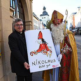 Der Nikolaus und der Generalsekretär des Bonifatiuswerkes, Monsignore Georg Austen, präsentieren den gemalten Nikolaus von Udo Lindenberg. (Foto: Theresa Meier)
