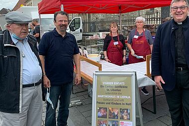 Ulrich Gelhard (v. l.), Eugen Riese und Msgr. Georg Austen am Waffelstand auf dem Paderborner Wochenmarkt. Foto: J. Birwer