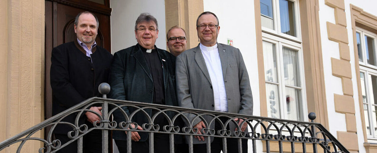 Matthias Micheel, Monsignore Georg Austen und Julian Heese vom Bonifatiuswerk begrüßen den Generalsekretär des Martin-Luther-Bundes (Zentralstelle), Pfarrer Michael Hübner, in Paderborn (v.l.) Foto: Theresa Meier