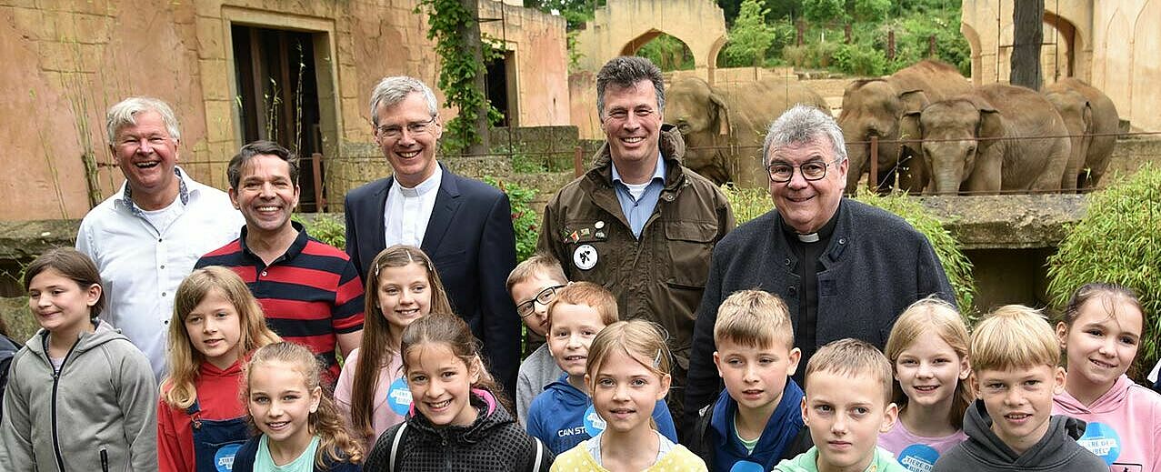 Setzten ein Zeichen für die Bewahrung der Schöpfung: Kinderliedermacher Reinhard Horn, TV-Moderator Juri Tetzlaff, der Hildesheimer Bischof Dr. Heiner Wilmer, Zoodirektor Andreas Michael Casdorff und Bonifatiuswerk-Generalsekretär Msgr. Georg Austen (v.l.) mit Viertklässlern der Kardinal-Galen-Schule Hannover. (Foto: Theresa Meier / Bonifatiuswerk)