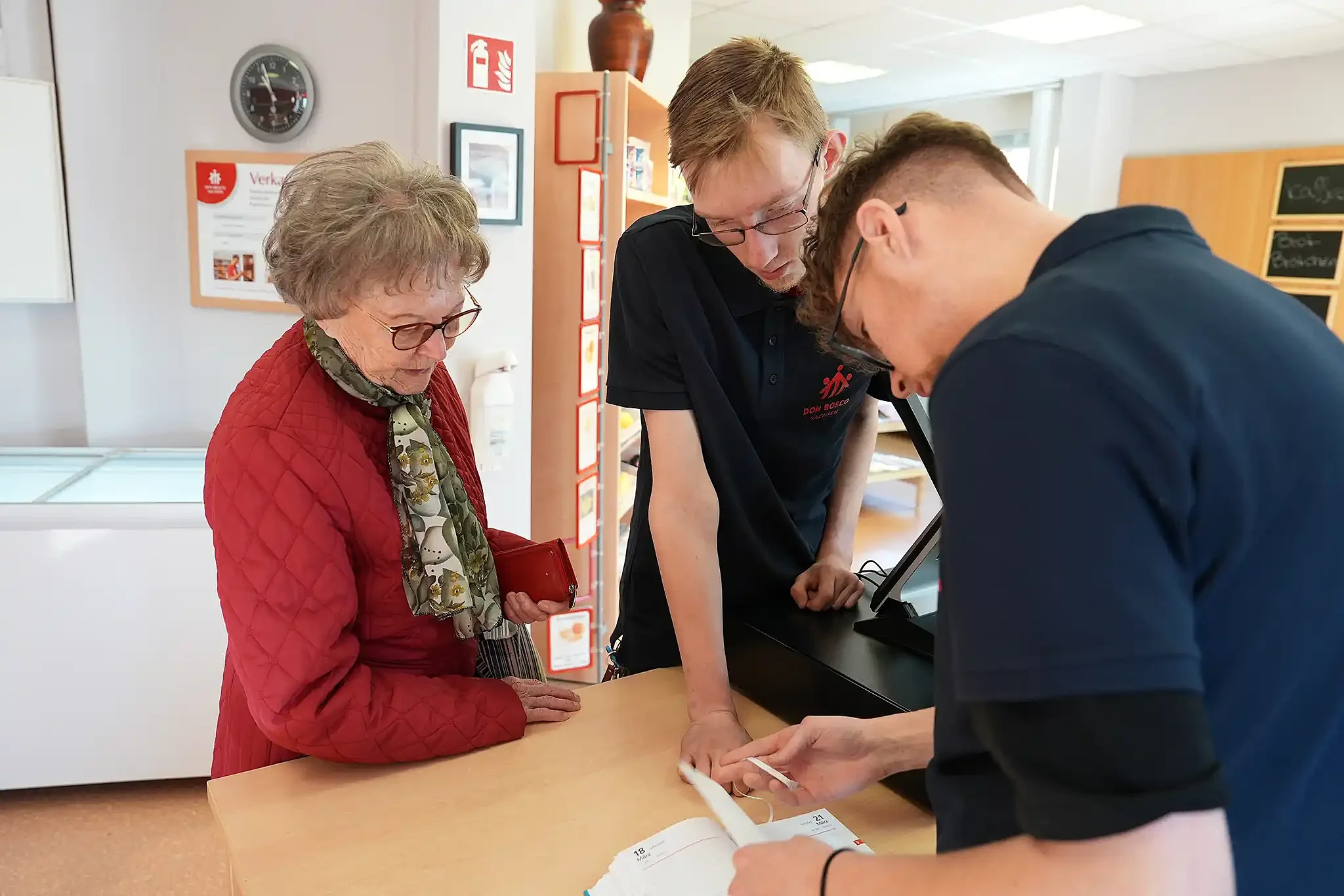 Maurice (17) (Mitte) macht eine berufsvorbereitende Bildungsmaßnahme im Don Bosco Eckladen in Hartmannsdorf - hier prüft er mit seinem Kollegen Leandro eine Bestellung für die 94-jährige Inge Steinbach / Foto: Theresa Meier