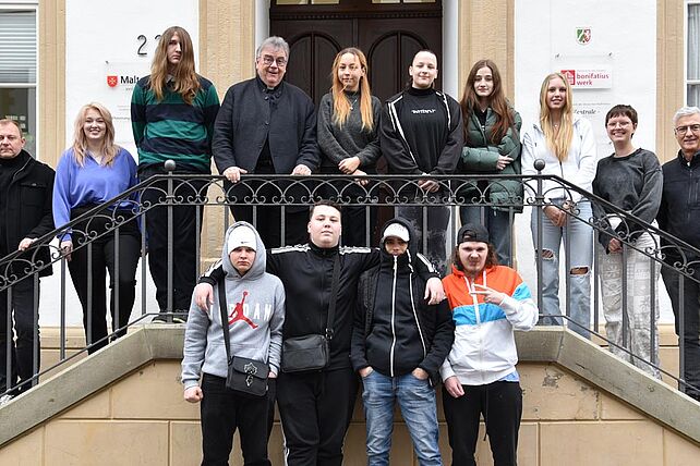 Neun Praktikantinnen und Praktikanten aus der Manege-Schule in Berlin-Marzahn mit ihrem Klassenlehrer Robert Lisiecki (links), Monsignore Georg Austen, Generalsekretär des Bonifatiuswerkes (mitte) und Dietmar Ahle vom Rotary-Club (rechts). (Foto: Pia Wittek)