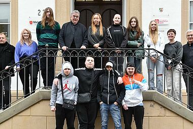 Neun Praktikantinnen und Praktikanten aus der Manege-Schule in Berlin-Marzahn mit ihrem Klassenlehrer Robert Lisiecki (links), Monsignore Georg Austen, Generalsekretär des Bonifatiuswerkes (mitte) und Dietmar Ahle vom Rotary-Club (rechts). (Foto: Pia Wittek)