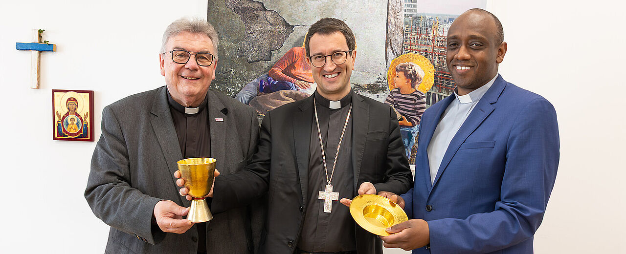 Monsignore Georg Austen überreichte Bischof Raimo Goyarrola und Generalvikar Jean Claude Kabeza (beide Helsinki) als Geschenk einen Kelch und eine Hostienschale. Foto: Hartmut Salzmann 