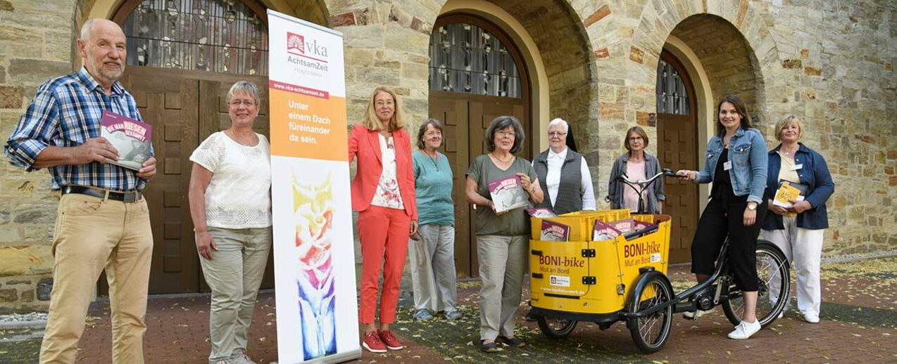 Dieter Päschke (Ehrenamtlicher), Maria Leifeld (Koordinatorin), Ulrike Molitor (Koordinatorin), Gabi Singh, Anne Kersting, Sr. Maria Ancilla König und Gudrun Hammerschmidt (Ehrenamtliche) freuen sich über die Bücher, die sie von Valeska Austen und Karin Stieneke (Bonifatiuswerk) überreicht bekommen (v.l.). (Foto: Theresa Meier)