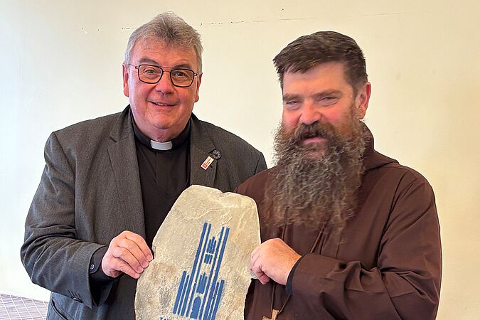 Msgr. Georg Austen (l.) bekommt von Bischof David Tencer eine alte Dachpfanne von der Christkönig-Kathedrale in Reykjavik geschenkt. (Foto: privat)