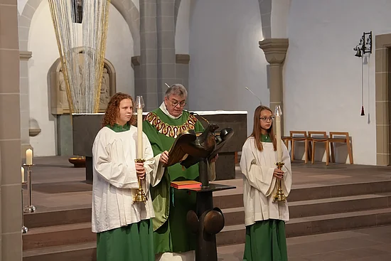 Monsignore Georg Austen trägt das Evangelium vor, flankiert von zwei Kerzenträgerinnen aus Litauen. (Foto: Marcus Thielking)