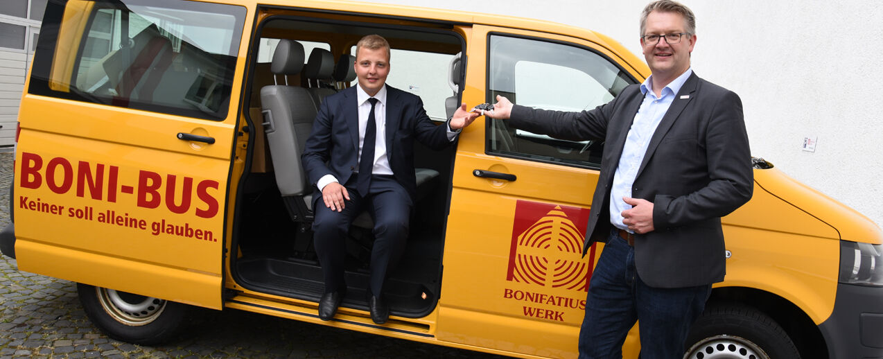 Priesteramtskandidat Vladislav Lukasevic aus Lettland (l.) freut sich über den BONI-Bus. Den Schlüssel übergibt ihm Thomas Twents vom Bonifatiuswerk. (Foto: Theresa Meier)