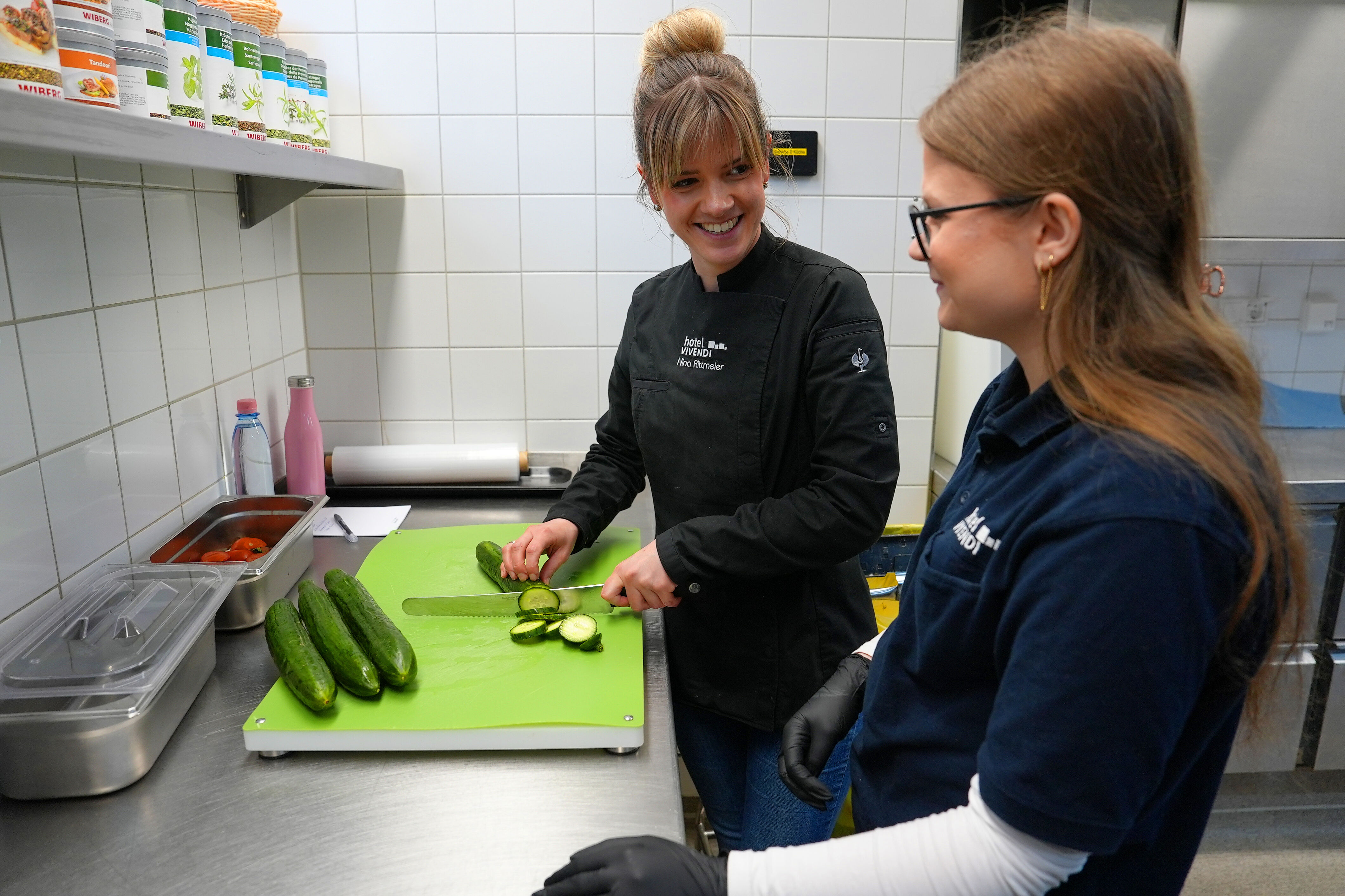 Hauswirtschafterin Nina Rittmeier gibt Lea Tipps und Tricks beim Schneiden von Gurken. (Foto: Theresa Meier)