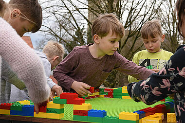 Erstkommunionkinder aus der Gemeinde St. Margaretha in Paderborn-Dahl bauen passend zum diesjährigen Bonifatiuswerk-Motto "Jesus, wo wohnst du?" ein Haus aus Duplo-Steinen. Foto: Theresa Meier