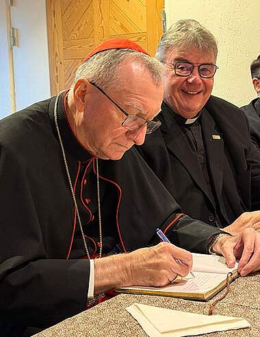 Kardinal Pietro Parolin trägt sich in das Gästebuch ein. (Foto: Bonifatiuswerk)