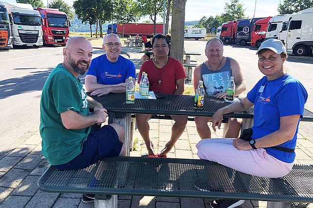 Das Team der Lenkpause im Gespräch mit LKW-Fahrern auf einem Rastplatz. Foto: Betriebsseelsorge Bodensee-Hohenzollern, Erzdiözese Freiburg
