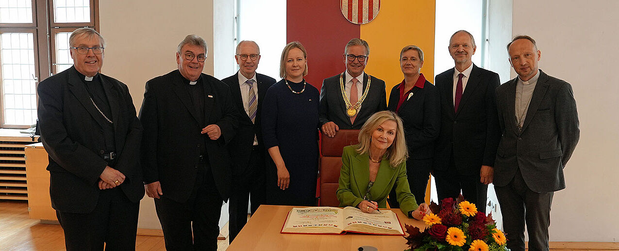 Trugen sich in das Goldene Buch der Stadt Paderborn ein (von links): Bischof Czeslaw Kozon, Monsignore Georg Austen, Manfred Müller, Marika Linntam, Veronika Wand-Danielsson, Alda Vanaga, Giedrius Puodžiūnas sowie Bischof Viktors Stulpins. (Foto: Simon Helmers)