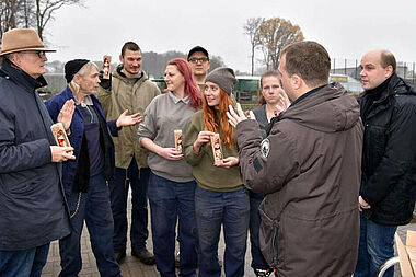 Michael Waterböhr (links außen), Mirko Wiedeking (2. Von rechts) und Simon Rüffin (rechts außen) schenken Inhaftierten Schoko-Nikoläuse. Foto: Sr. Theresita M. Müller 