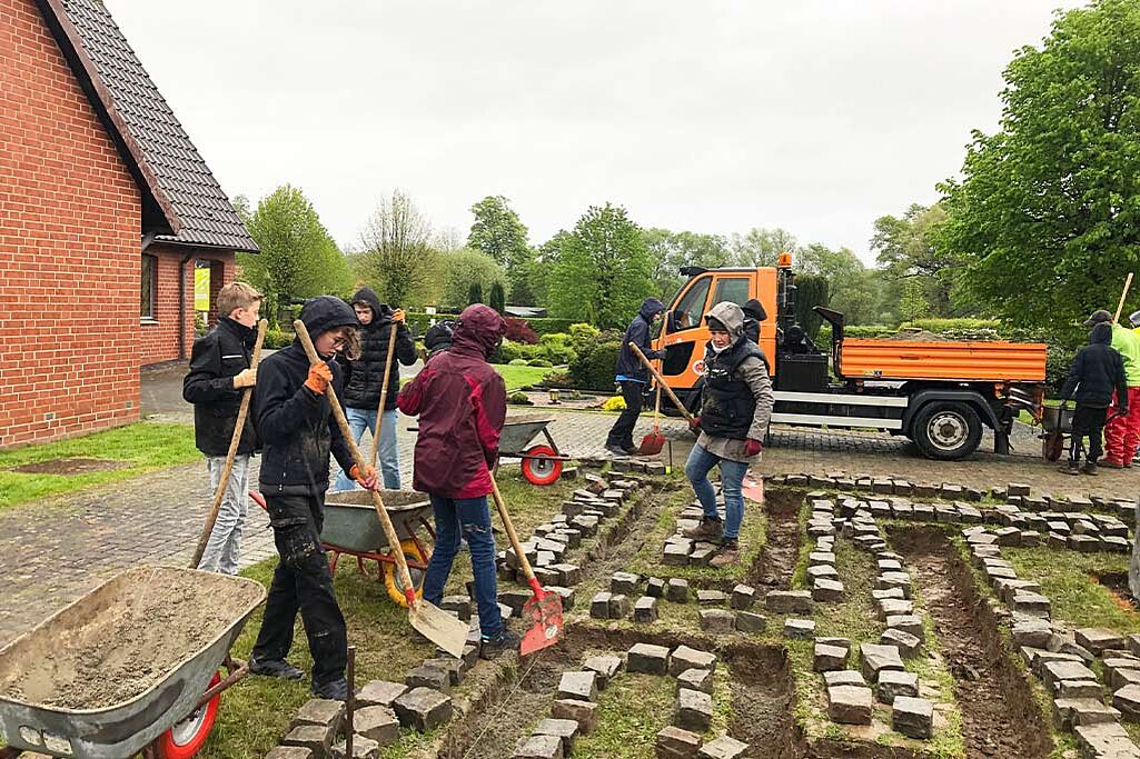 	Fleißig bei der Arbeit: Die Firmbewerber aus der Pfarrei Heilige Familie Bad Sassendorf schaffen den Trostweg auf dem Friedhof in Ostinghausen. Foto: Pastoraler Raum Soest